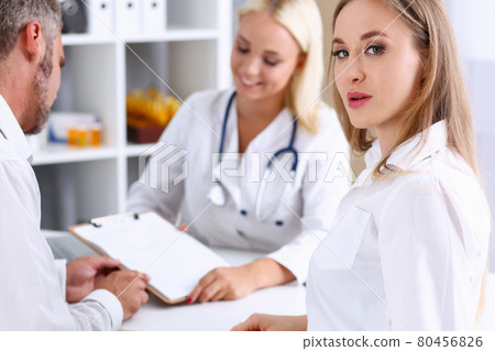 Female family doctor listen carefully young couple 80456826