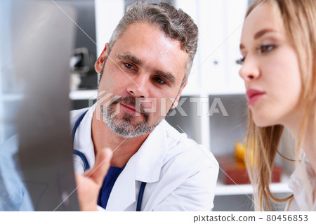 Mature male doctor hold in arm and look at xray photography 80456853