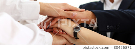 Group of people in suits crossed hands in pile Group of people in suits crossed hands in pile 80456871