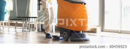 Man is cleaning hotel lobby with industrial vacuum cleaner Man is cleaning hotel lobby with industrial vacuum cleaner 80456923