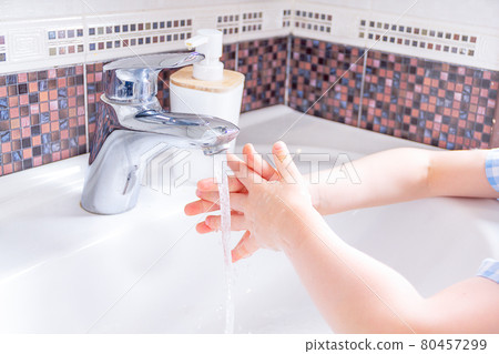 Washing hands with kid soap under the faucet with water. clean and Hygiene concept. Close up hands of kid. Washing hands with kid soap under the faucet with water. clean and Hygiene concept. Close up hands of kid. 80457299