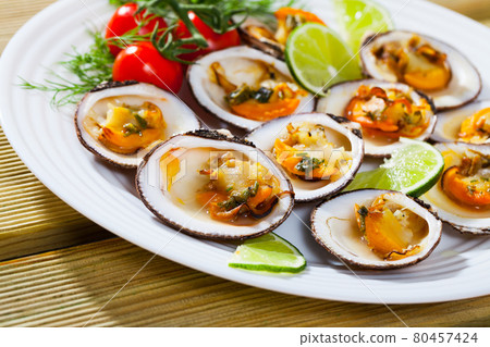 Deliciously baked dog with lemon, cherry tomatoes and greens at plate 80457424