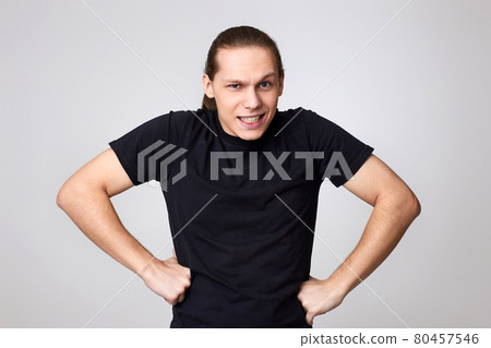 angry man in black t-shirt isolated on gray background 80457546