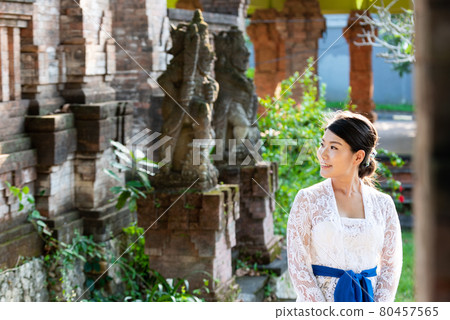 在巴厘島的一座傳統寺廟裡,一位身著傳統服飾 (Kebaya) 的女人 在巴厘島的一座傳統寺廟裡,一位身著傳統服飾 (Kebaya) 的女人 80457565