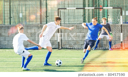 Junior football teams having scrimmage 80457590