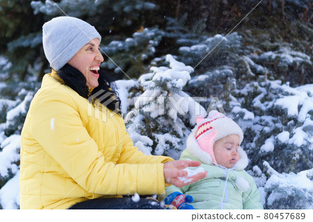 family portrait in the winter forest, mother and baby sitting and playing with snow, beautiful nature with snowy fir trees family portrait in the winter forest, mother and baby sitting and playing with snow, beautiful nature with snowy fir trees 80457689