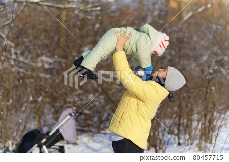 family portrait in the winter forest, mother and child, bright sunlight and shadows on the snow, beautiful nature 80457715