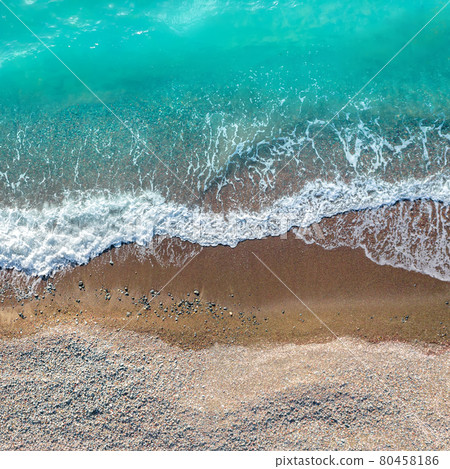 Sea waves over sand and pebbles beach, top view directly above 80458186