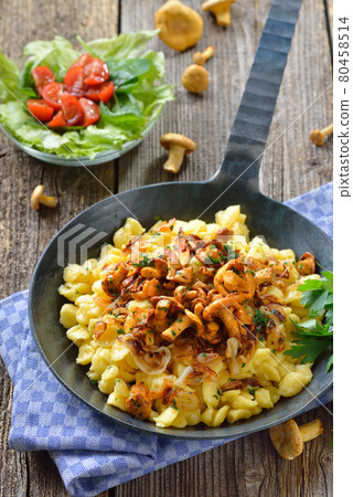 Vegetarian German spaetzle with fried chanterelles and onions served in a frying pan 80458514