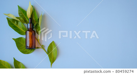 Flat lay ,top view of citrus essential oil or face serum in amber glass dropper bottle with fruit branch leaves on blue background.Natural cosmetic.Space for text Flat lay ,top view of citrus essential oil or face serum in amber glass dropper bottle with fruit branch leaves on blue background.Natural cosmetic.Space for text 80459274
