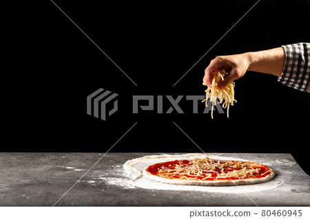 Making a pizza sprinkling dough with cheese Making a pizza sprinkling dough with cheese 80460945
