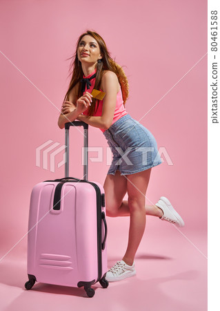 Tourist woman in summer casual clothes on pink background holding credit card. Tourist woman in summer casual clothes on pink background holding credit card. 80461588
