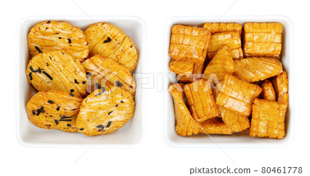 Senbei, Japanese rice crackers in white square bowls. Also sembei, crispy, bite-sized, savory snacks in various shapes and sizes, slightly salted, flavored with soy sauce, mirin and nori flakes. Photo 80461778