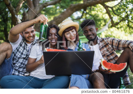 Multi ethnic people using laptop for video chat on nature Multi ethnic people using laptop for video chat on nature 80461876
