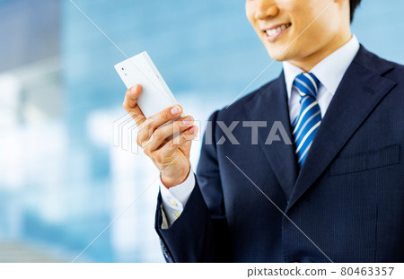 Image of a businessman operating a smartphone Image of a businessman operating a smartphone 80463357