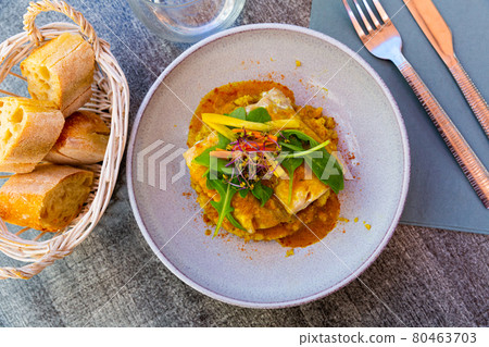 Codfish baked with curry and served with quinoa and greens Codfish baked with curry and served with quinoa and greens 80463703