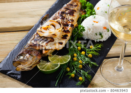 Baked trout with wine and garnish of rice Baked trout with wine and garnish of rice 80463943