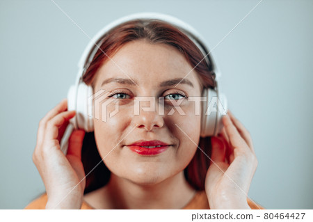 Beautiful joyful woman listen music dream close eyes white smile wear headphones isolated grey background 80464427