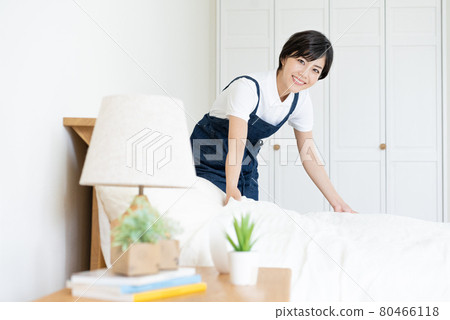 Housekeeping, house cleaning, young woman doing bed-making 80466118