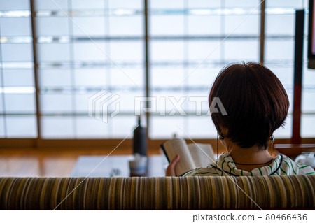 Woman reading in the living room in the morning (zoom) 80466436