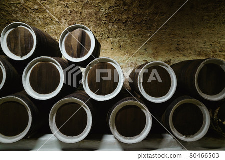 Old wine oak barrels in the cellar at the winery Old wine oak barrels in the cellar at the winery 80466503