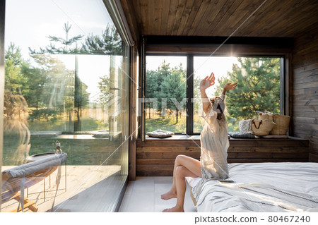 Woman wakes up at country house in nature 80467240
