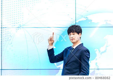 A businessman standing in front of a large display A businessman standing in front of a large display 80468082