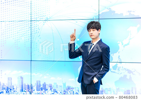 A businessman standing in front of a large display A businessman standing in front of a large display 80468083
