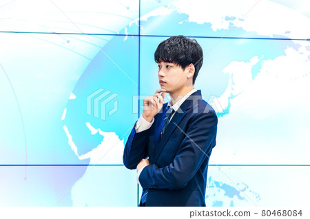 A businessman standing in front of a large display 80468084