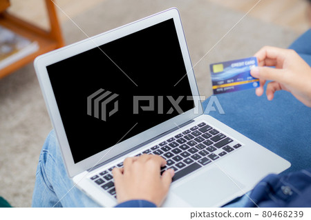 Hand of young man using laptop computer display blank screen shopping online with credit card. Hand of young man using laptop computer display blank screen shopping online with credit card. 80468239