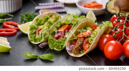 Mexican tacos with beef, tomatoes, avocado, onion and salsa sauce Mexican tacos with beef, tomatoes, avocado, onion and salsa sauce 80469290