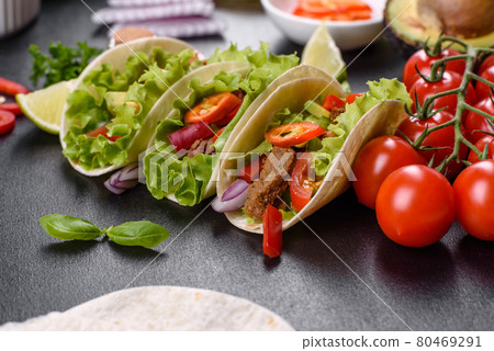 Mexican tacos with beef, tomatoes, avocado, onion and salsa sauce Mexican tacos with beef, tomatoes, avocado, onion and salsa sauce 80469291