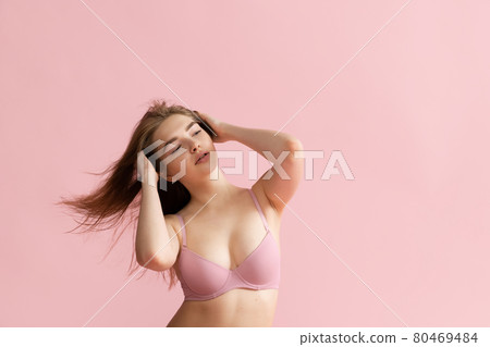 Adorable girl in lingerie posing isolated over pink studio background. Natural beauty, spa, cosmetics, fitness and aesthetic cosmetology concept. 80469484
