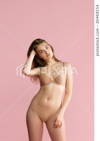 Young woman in lingerie isolated over pink studio background. Beauty, fitness, diet, sports, plastic surgery and aesthetic cosmetology concept. 80469554