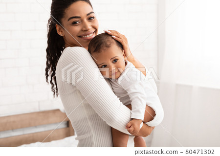African American Mother Holding Her Baby Son Standing In Bedroom African American Mother Holding Her Baby Son Standing In Bedroom 80471302