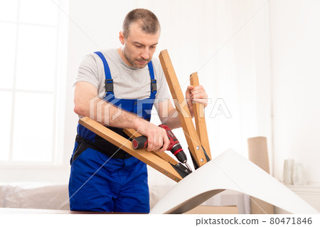 Professional Craftsman Carpenter Installing Table Using Electric Drill Indoors Professional Craftsman Carpenter Installing Table Using Electric Drill Indoors 80471846