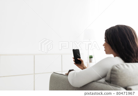 Home temperature, safety and control on mobile app. African american woman using smartphone, sitting on sofa, copy space Home temperature, safety and control on mobile app. African american woman using smartphone, sitting on sofa, copy space 80471967