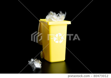 Recycled plastic. Bin container for disposal garbage waste and save environment. Yellow dustbin for recycle paper and glass can trash isolated on black background. 80473012