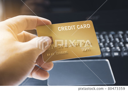 Credit card premium in the hand with computer keyboard background 80473359