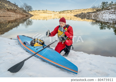Hot tea break during winter paddling 80473911
