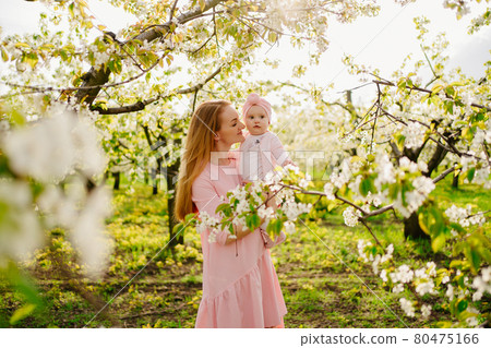 mother with baby in arms in flowering garden. surgery for child with cleft lip. mother with baby in arms in flowering garden. surgery for child with cleft lip. 80475166