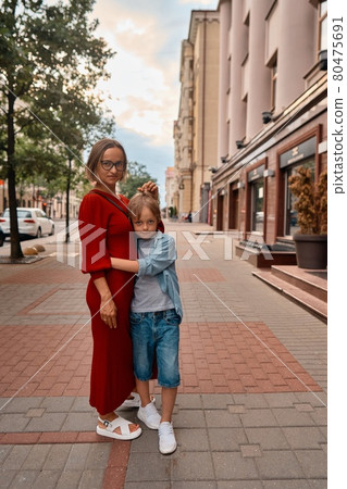 Adorable little boy and mother hugging in summer city Adorable little boy and mother hugging in summer city 80475691