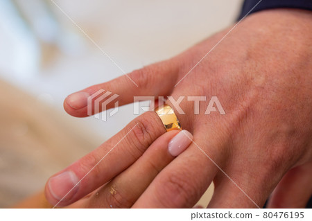 mans hand putting a wedding ring on the brides finger. mans hand putting a wedding ring on the brides finger. 80476195
