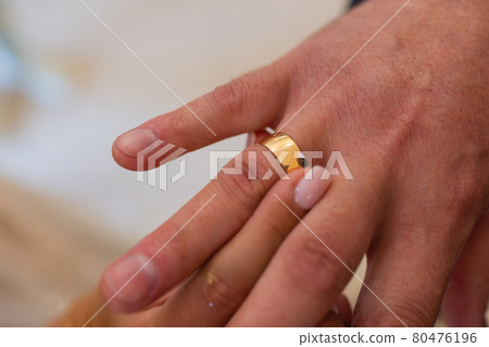 mans hand putting a wedding ring on the brides finger. mans hand putting a wedding ring on the brides finger. 80476196