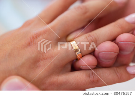 mans hand putting a wedding ring on the brides finger. mans hand putting a wedding ring on the brides finger. 80476197