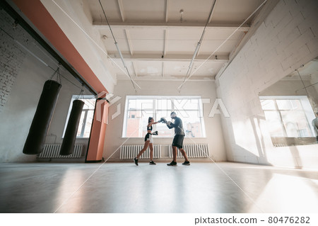 Female MMA fighter training punches technique 80476282