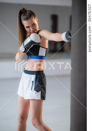 Beautiful Kickboxing woman tired from training in fitness studio Beautiful Kickboxing woman tired from training in fitness studio 80476307