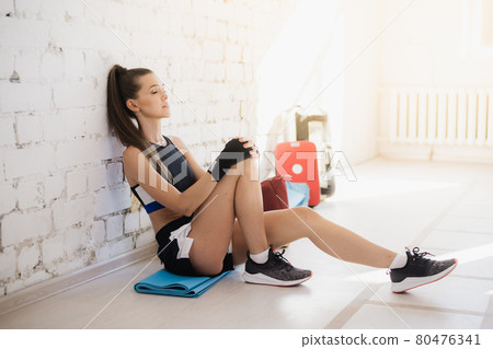Beautiful Kickboxing woman tired from training in fitness studio Beautiful Kickboxing woman tired from training in fitness studio 80476341
