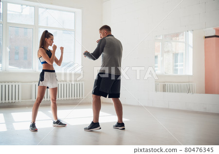 Female MMA fighter training punches technique 80476345