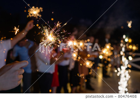 Picture showing group of friends having fun with sparklers. 80476408